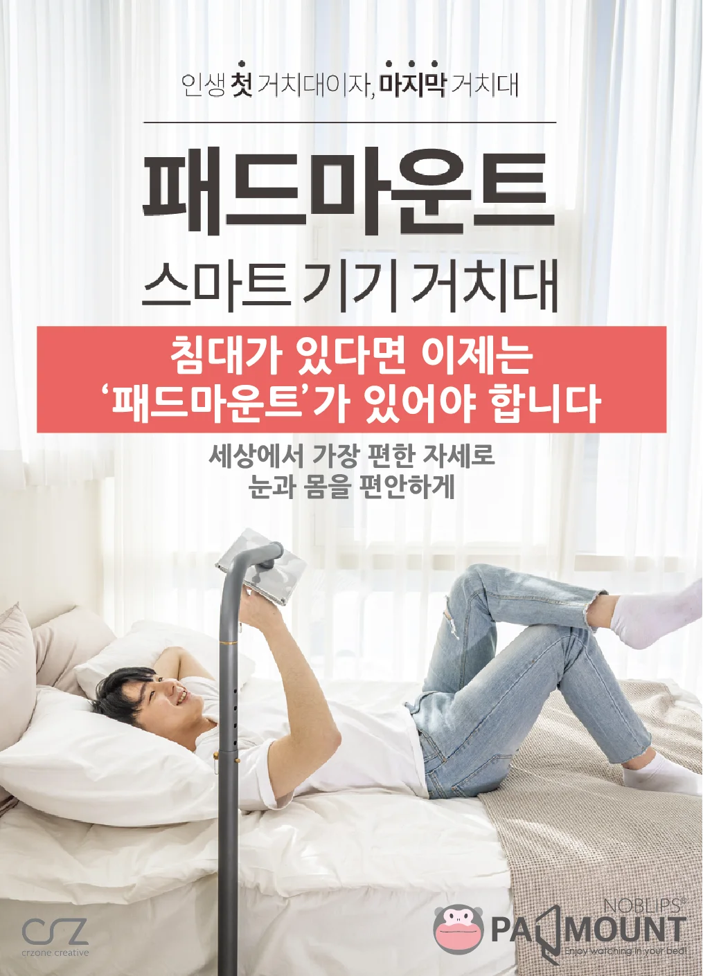침대에 누워 스마트 기기를 거치대에 거치한 남성